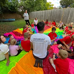 Volunteers playing parachute games with children during school holidays