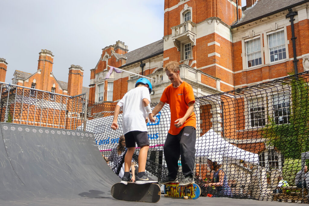Children learning to skate on a half-pipe at the Sticks N Stones Festival in Medway Kent