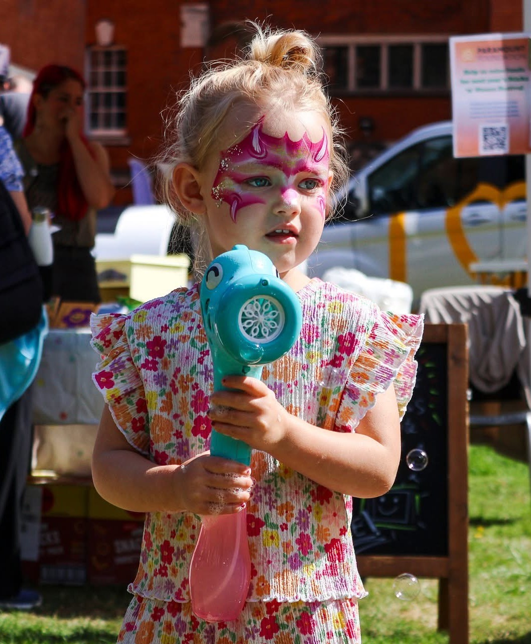 Young child with a face paint playing at a family day out